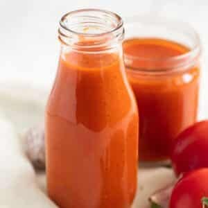 homemade tomato ketchup made with fresh tomatoes in a small bottle and in a jar.