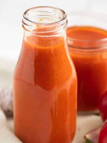 homemade tomato ketchup made with fresh tomatoes in a small bottle and in a jar.