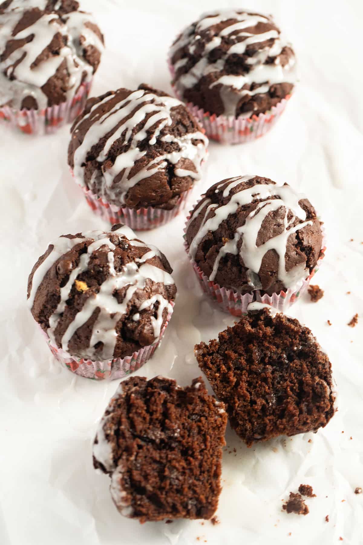 five glazed chocolate muffins with cocoa and pumpkin and one split in the middle.