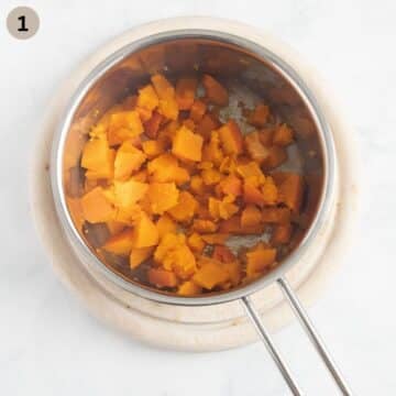 cooked pumpkin pieces in a small saucepan for making puree for baking muffins.