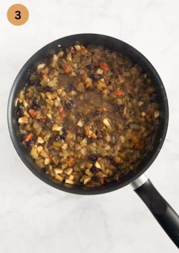 cooked and thickened mincemeat with green tomatoes and apples in a large saucepan.