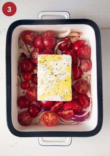 cherry tomatoes and a block of feta drizzled with oil in a baking dish.