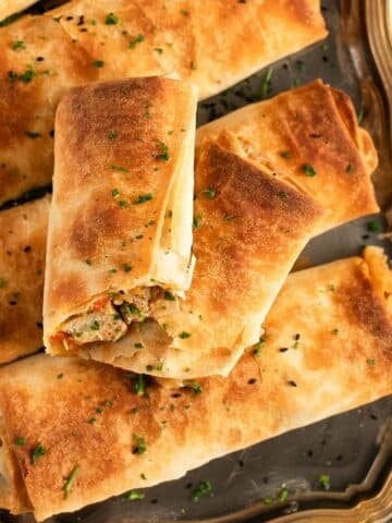 golden and crispy chicken filo parcels sprinkled with parsley.