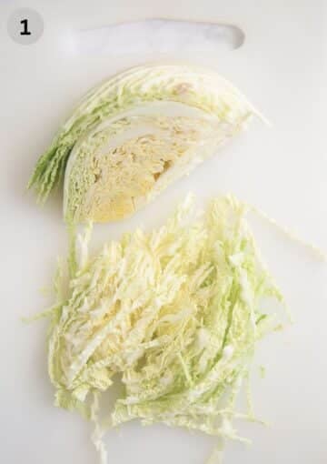 finely sliced savoy cabbage on a cutting board.