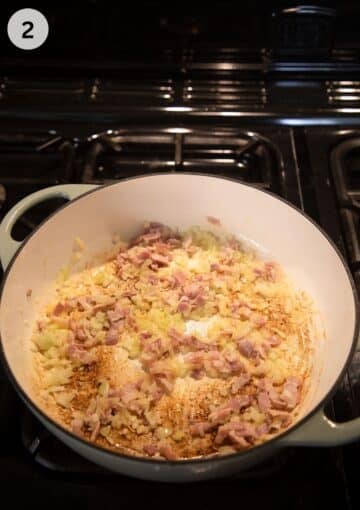 sauteing bacon, onions and garlic in a pot for making savoy cabbage.