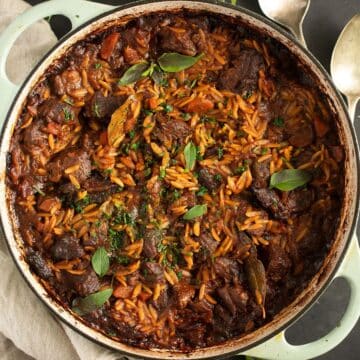 greek youvetsi recipe with orzo, beef and tomato sauce in a large dutch oven.