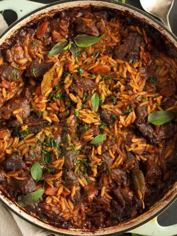 greek youvetsi recipe with orzo, beef and tomato sauce in a large dutch oven.