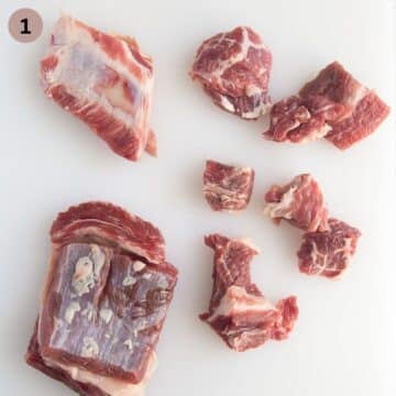 removing the bones and cutting beef short ribs into pieces to make youvetsi.