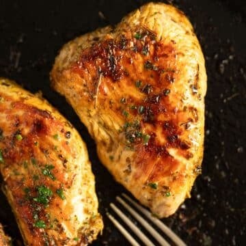 Juicy, fully cooked turkey steaks in a cast iron skillet, perfectly seared and ready to eat.