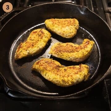 golden seared turkey steaks in a cast iron skillet on the stovetop.
