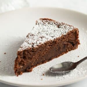 a slice of chocolate and ricotta cake with a spoon on a plate.