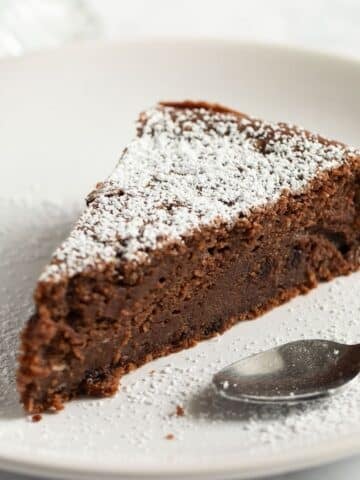 a slice of chocolate and ricotta cake with a spoon on a plate.