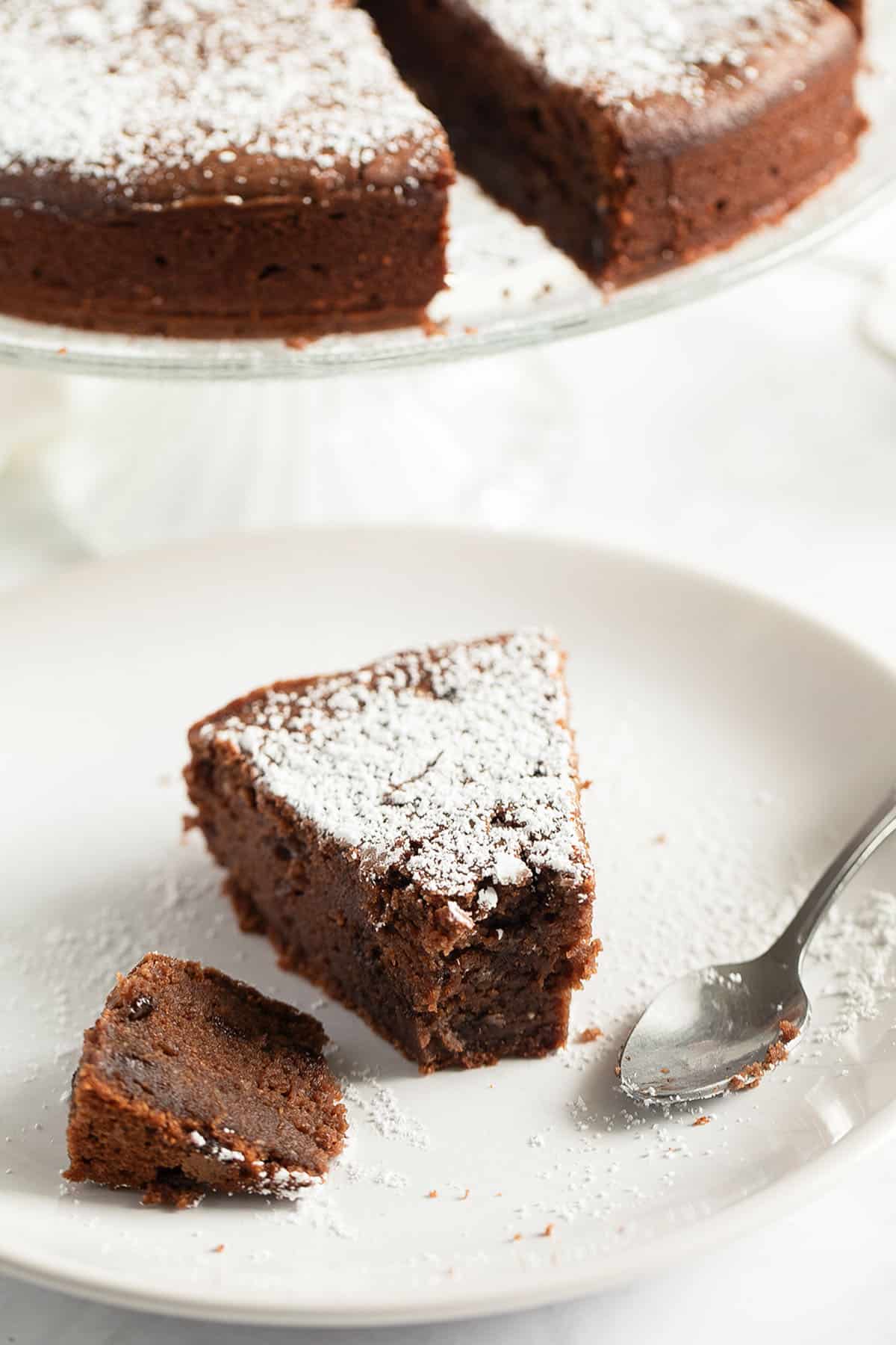slice of chocolate cake with ricotta, one piece broken from it.
