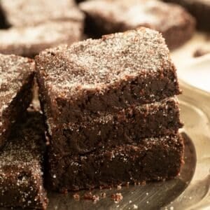 three pieces of cocoa shortbread sprinkled with granulated sugar on a vintage plate.