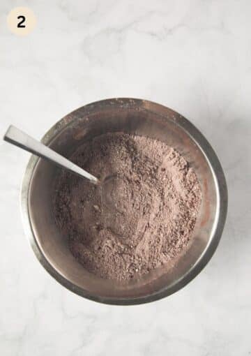 mixed flour, cocoa and salt in a bowl with a spoon in it.
