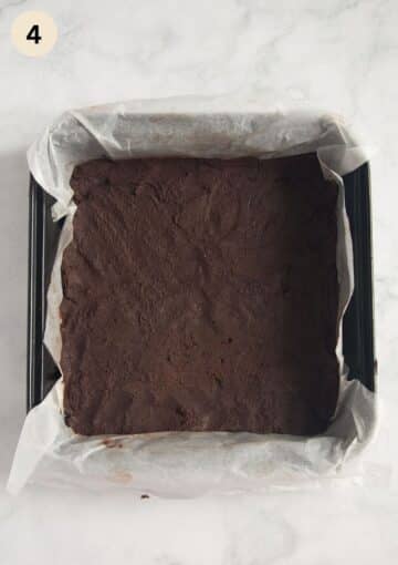 pressed cocoa shortbread dough into a squared baking tin lined with white parchment paper.