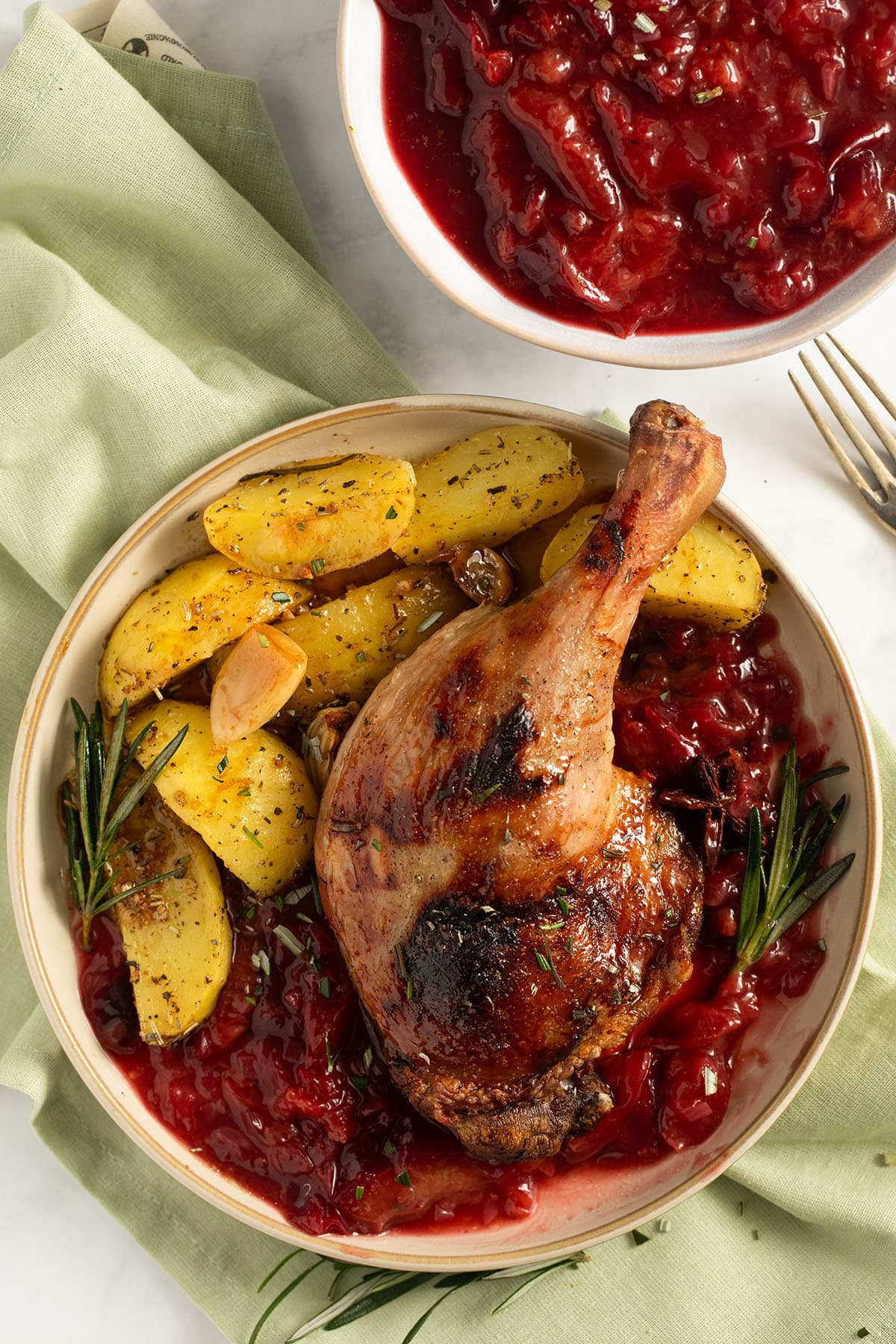 one large and crispy duck leg served with plum sauce and potato wedges.