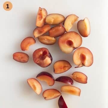 sliced red plums for making sauce on a cutting board.