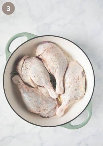 four uncooked duck legs in a round dutch oven.