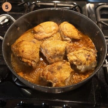 six chicken thighs simmering in sauce.