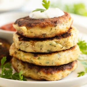 crispy fried mashed potato patties or cakes with a dollop of sour cream and parsley on top.