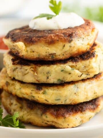 crispy fried mashed potato patties or cakes with a dollop of sour cream and parsley on top.