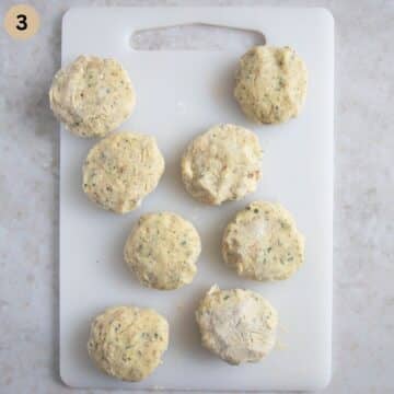 shaped but uncooked mashed potato patties on a cutting board.