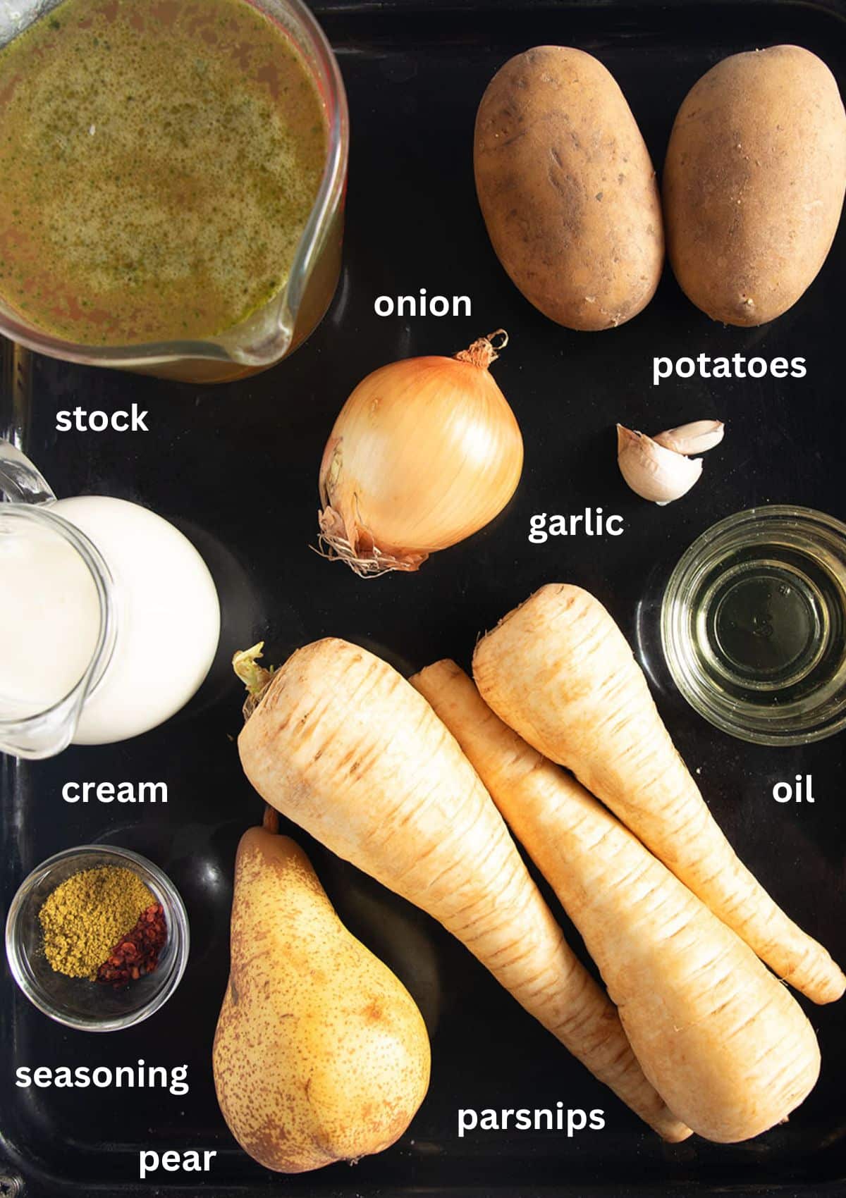 labeled ingredients for making parsnip soup with potatoes, onion, pear, cream, and curry.