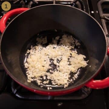 sauteing chopped onion to make parsnip soup in a large dutch oven.