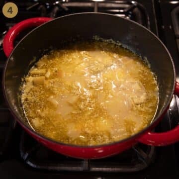 simmering parsnip soup with pears and potatoes in a red dutch oven.