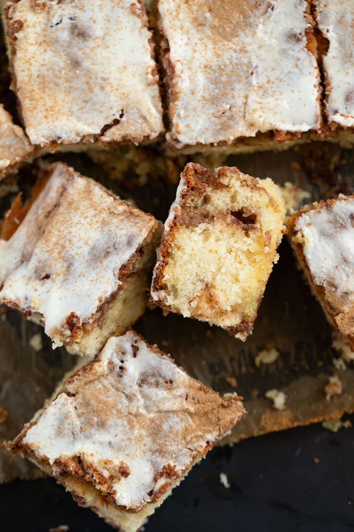 square pieces of cinnamon cake with cream cheese glaze.