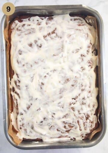 cinnamon cake glazed with cream cheese, butter and icing sugar mixture in the baking pan.