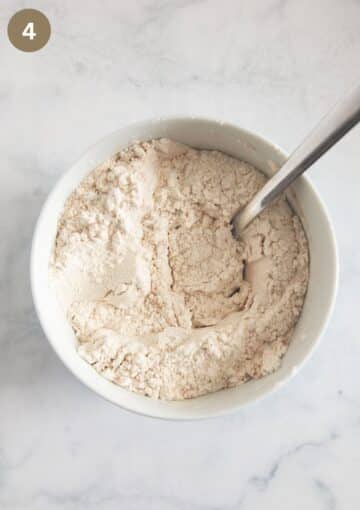 mixed flour, spices, and baking powder for making irish cake in a bowl with a spoon in it.