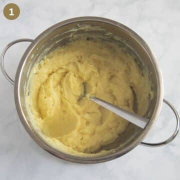 stirring mashed potatoes with a spoon in a pot.