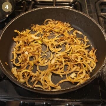 onion slices cooking in a skillet to make onion gravy.