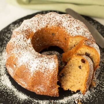 irish coffee cake sprinkled with confectioner's sugar and a few sliced pieces.