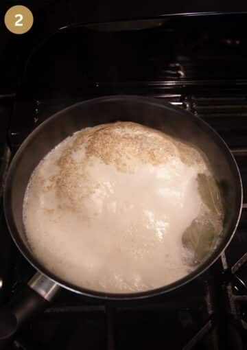 milk mixed with seasoning boiling in a saucepan for making white sauce.