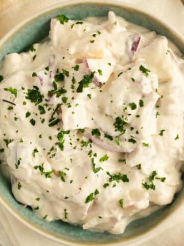 german herring salad with apples and onions in a small bowl.