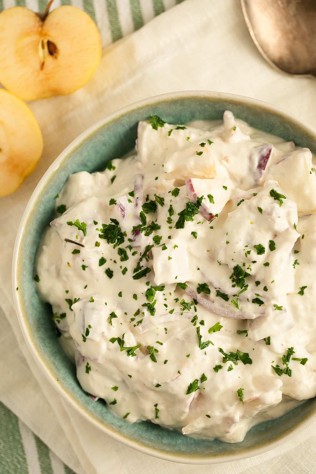 creamy german salad with herring and sour cream in a bowl.