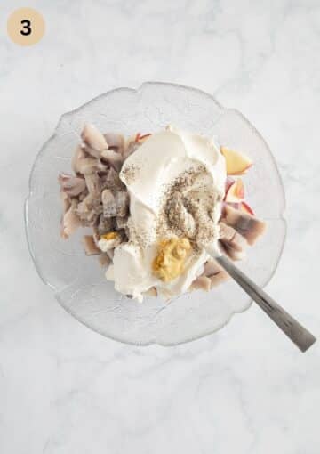 ingredients fo rmaking herring salad with sour cream, apples and onions in a bowl.