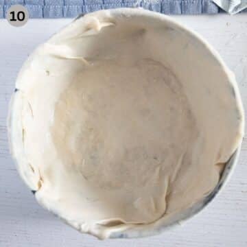 covering a springform with layers of streched dough to make italian pie.