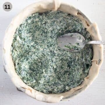 adding spinach filling to a springform lined with pastry and making intendations with a spoon.
