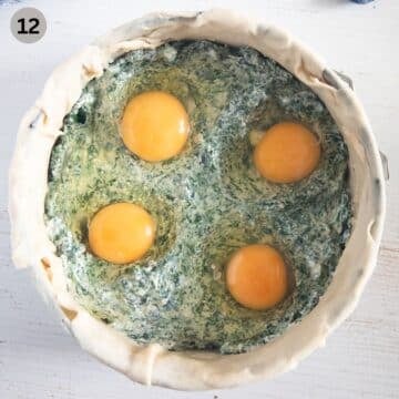 four cracked eggs onto spinach filling in baking form to make pie.