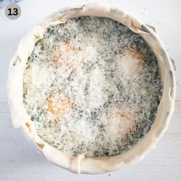 italian pie showing the uncooked filling topped with cracked eggs and parmesan in a springform.