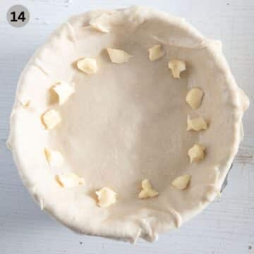 adding butter pieces to the sides of dough before rolling the dough to make the edges for the pie.