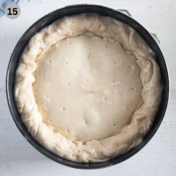 pricking an unbaked italian pie with a toothpick in a springform.