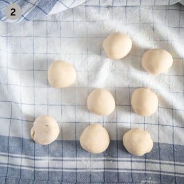 eight small balls of dough for rolling into layers to make pie on a floured kitchen towel.