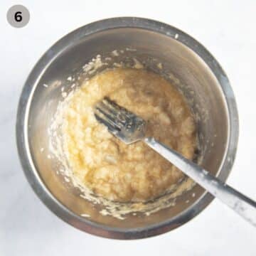 mashing beaten egg with soaked bread to make pie filling in a bowl with a fork.