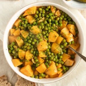 greek peas and potatoes in a bowl with a fork in it.