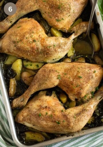 roasted chicken legs on potatoes and wild garlic in a baking dish.